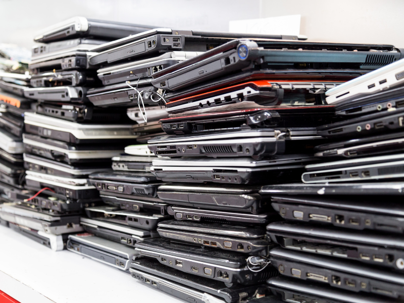 Stacks of old business laptops that need to be recycled