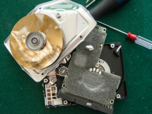 A computer hard drive that has been taken apart with a screwdriver