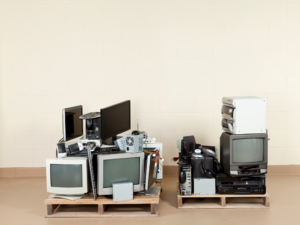 two stacks of old electronics piled on top of pallets