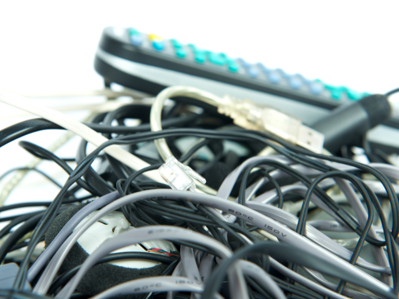 A pile of old cables, wires, and electronics that need to be disposed of.