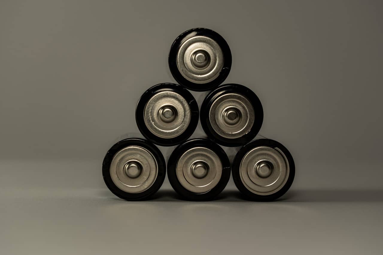 a stack of black and silver batteries resting on a surface