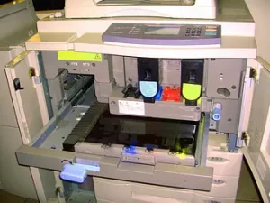 A photocopier opened up to reveal interior parts, including chromium components